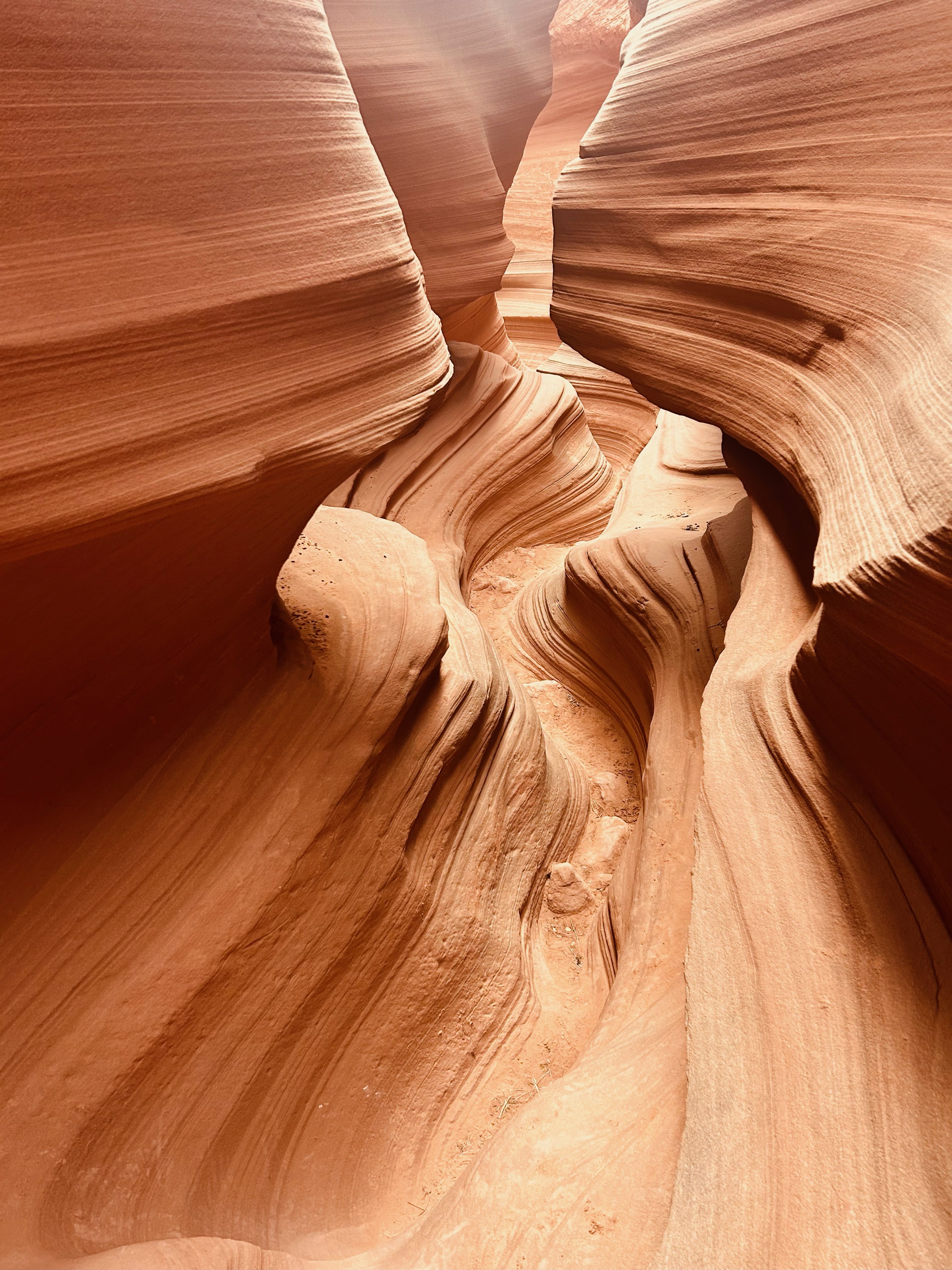 Sunlight filtering down through the sculpted, layered walls of a sandstone slot canyon