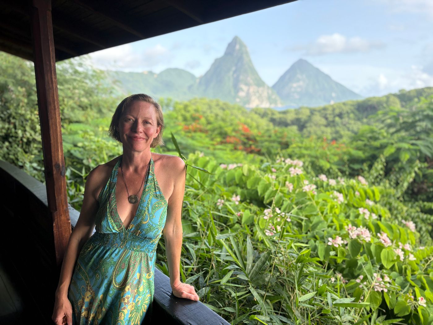 Elisa Clay, NP, smiling outdoors with a mountain valley behind her