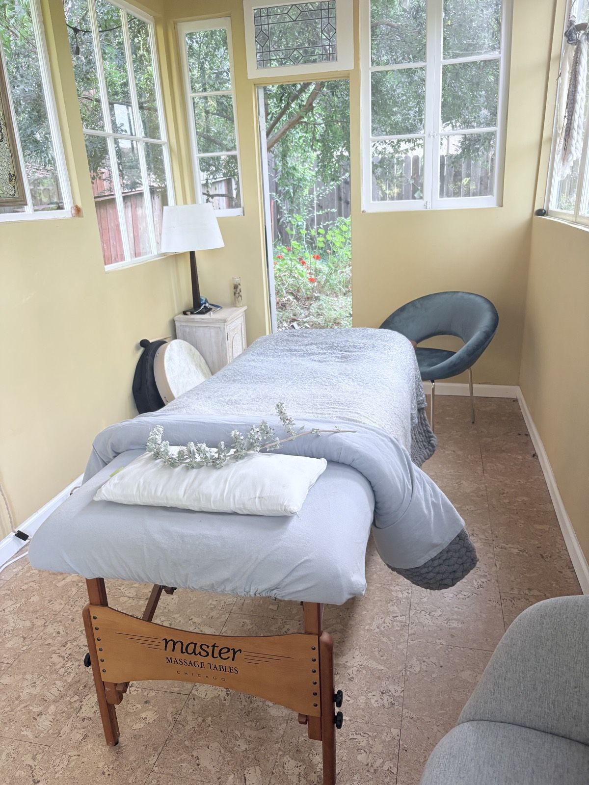 A peaceful healing table draped with blankets in a calm, naturally lit space